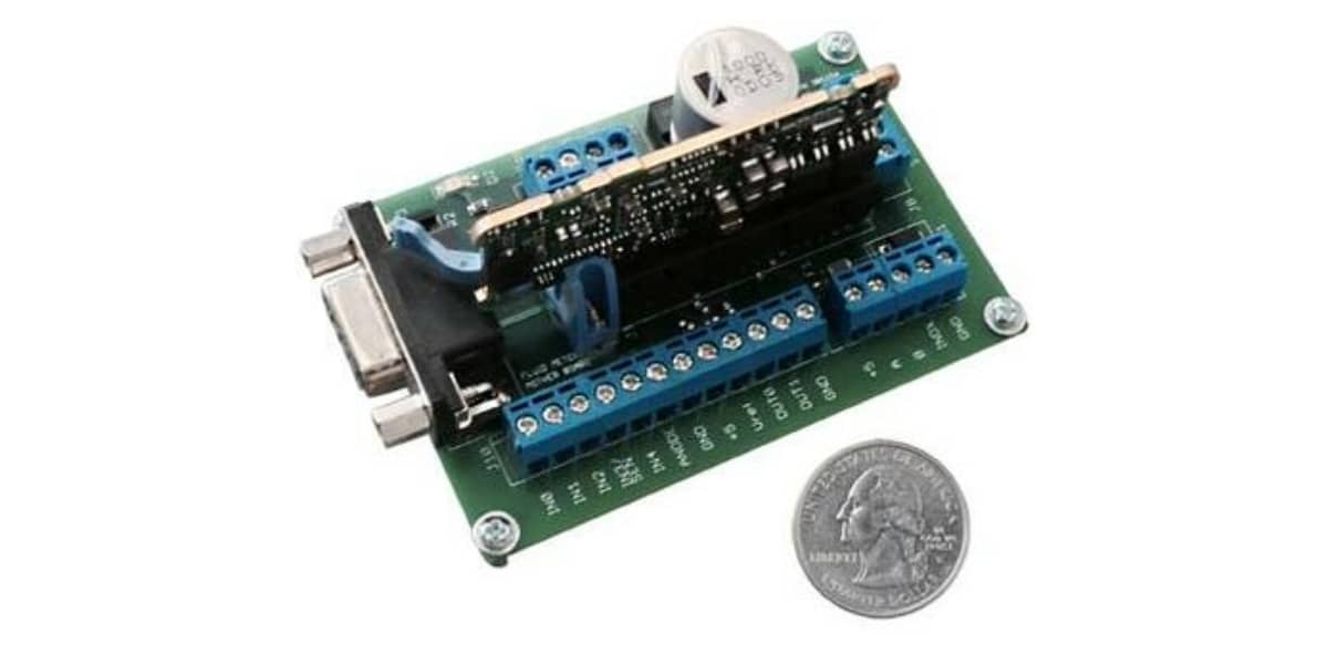Small electronic circuit board with various components and a quarter for scale